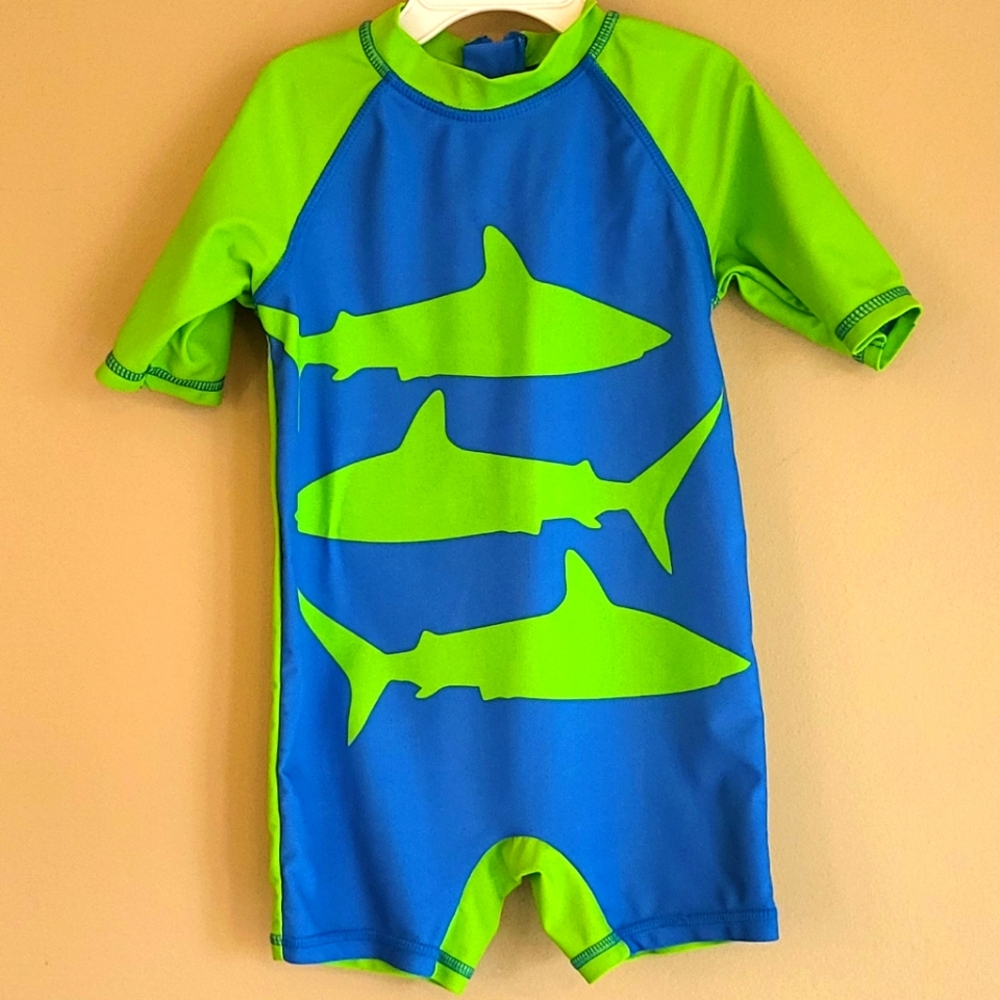 Blue and green shark print short sleeved rashguard.